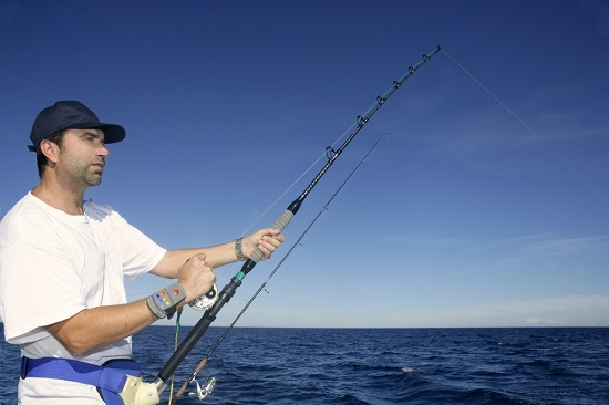 deep sea fishing a man standing next to a body of water