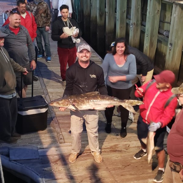 a group of people standing next to a fence