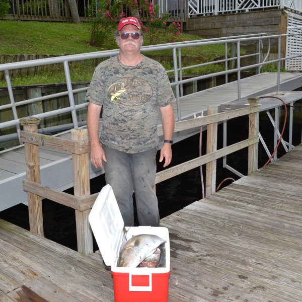 a man standing next to a fence