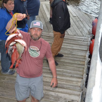 a group of people standing next to a man holding a hot dog