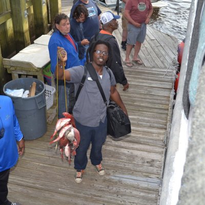 a group of people standing next to a fence