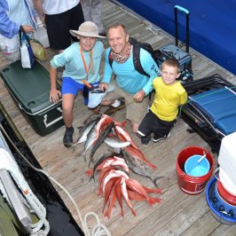 a group of people sitting on a suitcase