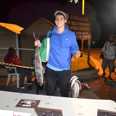 a group of people standing on top of a cutting board with a cake