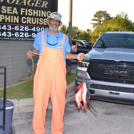 a man standing in front of a car posing for the camera