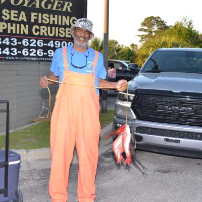 a man standing in front of a car posing for the camera