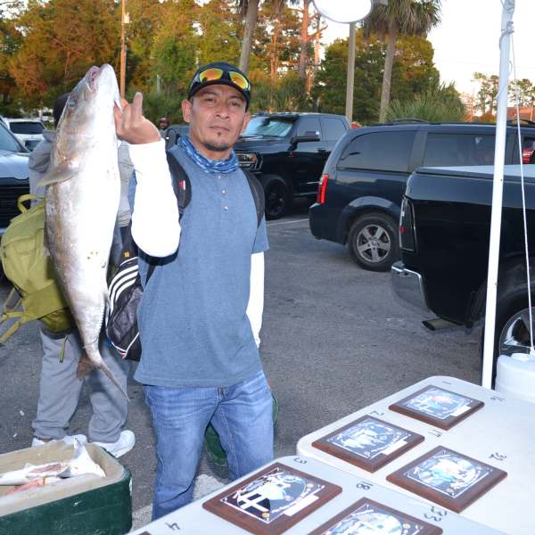 a man standing on top of a car posing for the camera