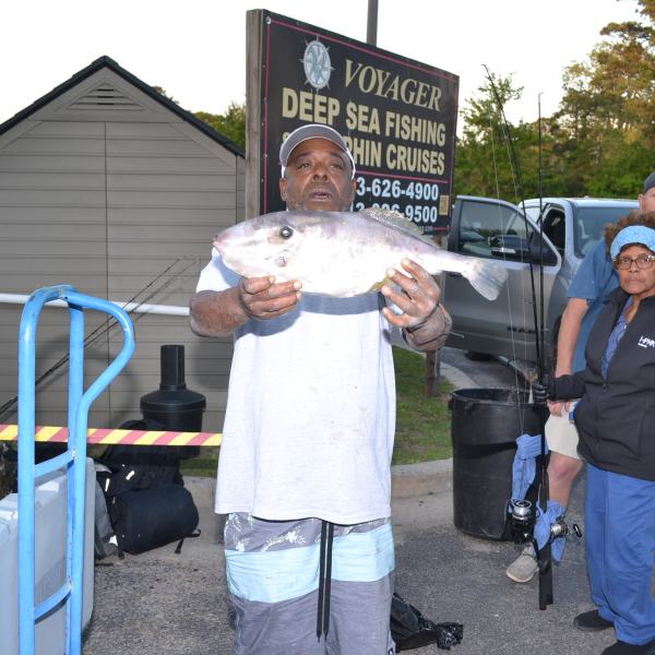 a group of people standing next to a man holding a sign