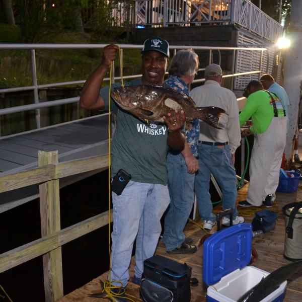 a man standing next to a fence