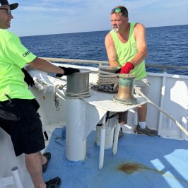 a man and woman sitting next to a body of water