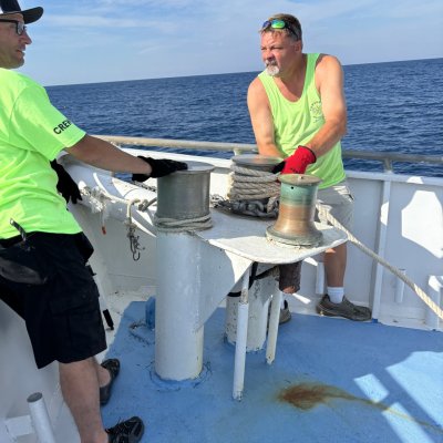 a man and woman sitting next to a body of water
