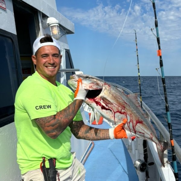 a man holding a fish on a boat