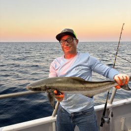 a man holding a fish in the water