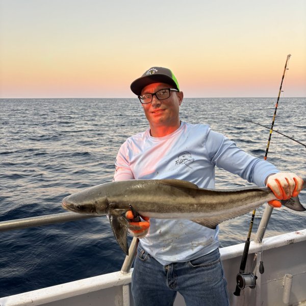 a man holding a fish in the water
