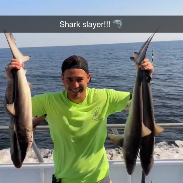 a man holding a fish on a boat